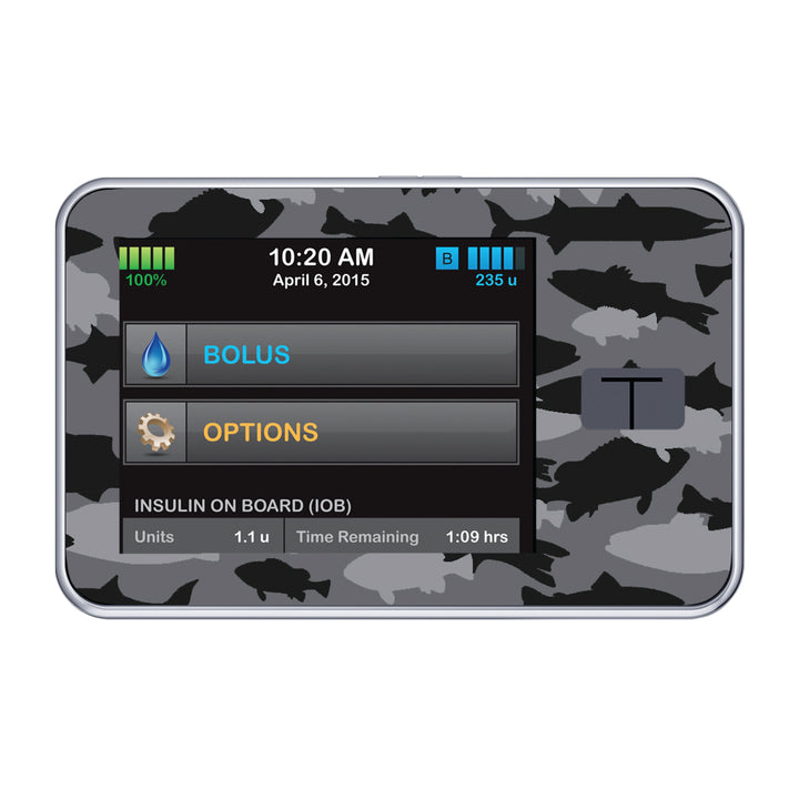 A fun sticker that has black and grey fish in a camouflage pattern on the Tandem t-slim insulin pump