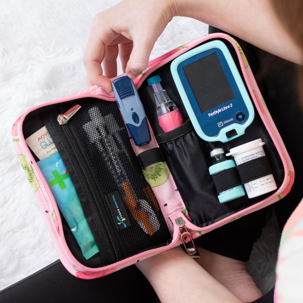 Sugar Medical Diabetes Supply Case II pink with watermelons opened on girl’s lap with diabetic supplies organized in bag. 