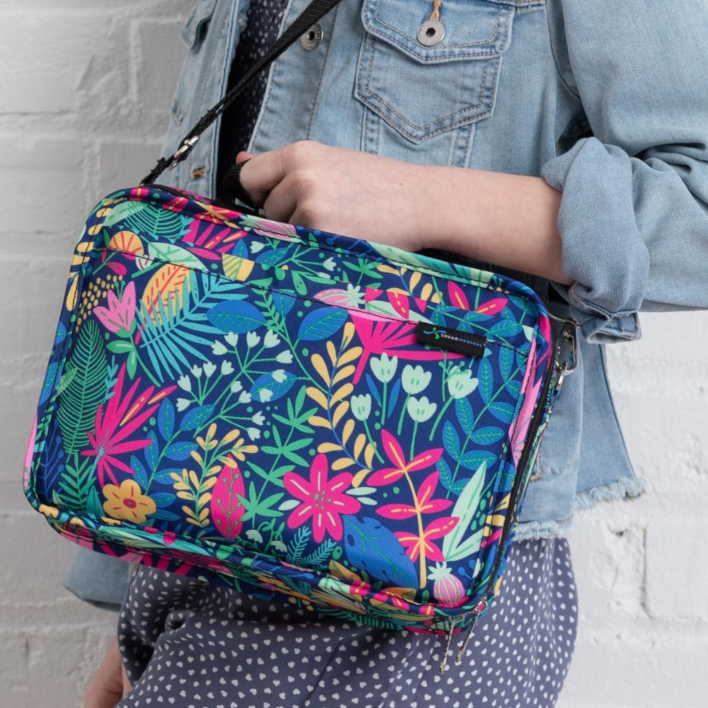 Diabetes Insulated Travel Bag in Blue Floral carried over the shoulder of a girl and being held by the handle. 