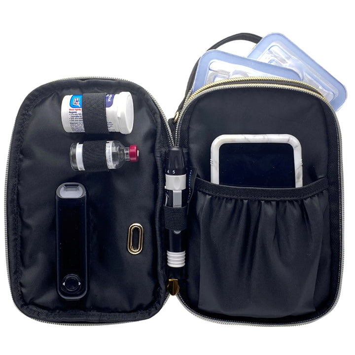 Black diabetes purse with Omnipod 5 controller and glucose testing supplies in elastic loops.